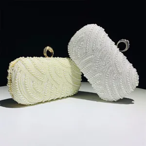 Elegant pearl evening clutch bag for women, exquisite beaded party purse with metal ring handle.