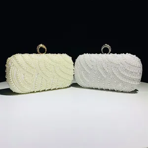 Pearl evening clutch bag detail showing exquisite beadwork and metal ring clasp design.