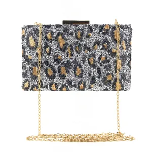 Gros plan sur le sac de soirée élégant à motif léopard en sequins avec chaîne dorée.