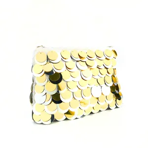 Detail view of a stunning sequin evening clutch bag featuring shimmering gold and silver disc scales.