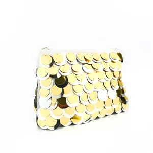 Close-up detail of sparkling gold and silver sequin texture on elegant evening clutch.