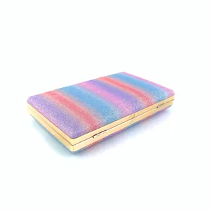 Detailed view of the colorful glitter hard-shell clutch bag with polished gold metal trim.