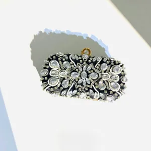 Detailed view of black crystal evening clutch bag with handcrafted rhinestones and pearl clasp.