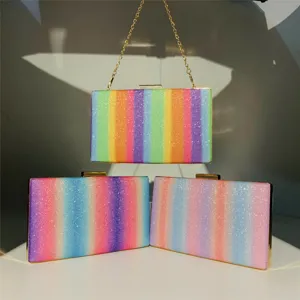 Detailed view of women's sparkling glitter rainbow clutch evening bag with gold chain and frame.