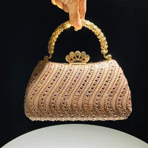 Elegante bolso de noche dorado con diamantes de imitación y cierre de corona brillante.