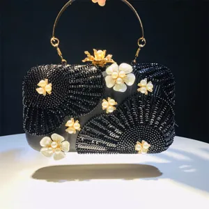 Black beaded evening clutch bag with elegant faux pearls, floral design and gold metal handle.