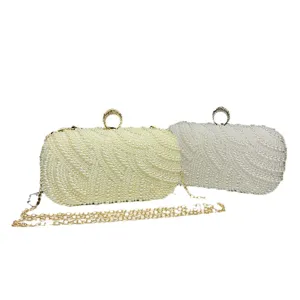Exquisite detail showing pearl beaded texture and metal ring clasp of the evening clutch bag.