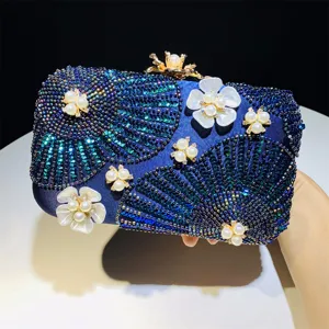 Detailed view of dark blue evening clutch bag with sequin bead fan patterns and pearl floral accents.