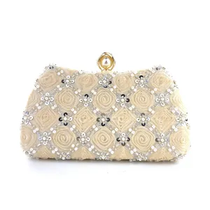 Detailed close-up of champagne beaded evening clutch with pearl clasp and floral mesh.