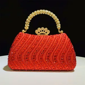 Bolso de noche rojo con pedrería brillante, asa dorada y cierre de corona para bodas.