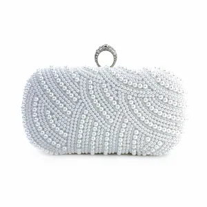 Detailed view of white pearl evening clutch bag with rhinestone ring clasp for party.