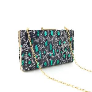 Gros plan détaillé d'une élégante pochette léopard à sequins brillants avec chaîne dorée.
