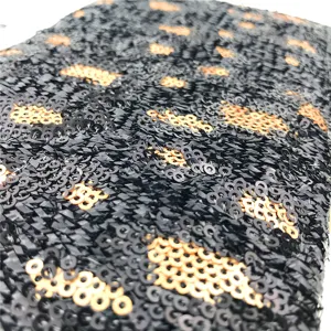 Vue détaillée d'une pochette noire et dorée à sequins et motif léopard, texture raffinée.