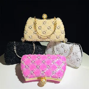 Detail view of handmade beaded evening clutch bag with pearl clasp and elegant floral pattern.