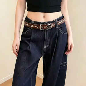 Close-up detail of the punk style brown leather rivet belt featuring metal grommets and rings.