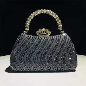 Detalle de bolso de noche con diamantes de imitación, asa de cristal y cierre de corona.