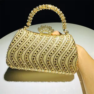 Bolso de noche dorado con diamantes de imitación, cierre de corona y asa de cuentas.