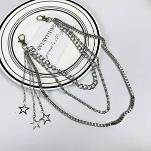 Detail shot of multi-layer metal pants chain with star charms, hip-hop cyberpunk style.