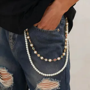Detail shot of a trendy double-layer pearl pants chain with sun gemstone charms for women.