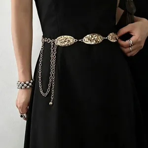 Close-up view of a chic gold irregular oval metal waist chain with delicate dangling chains.