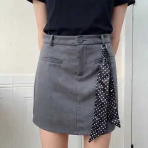 Dettaglio di foulard in seta lungo a pois neri e bianchi, elegante accessorio per donna.
