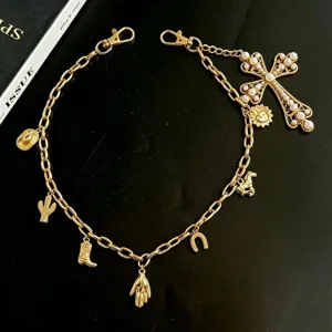 Detailed shot of gold punk waist chain with pearl cross charm, western style body jewelry.