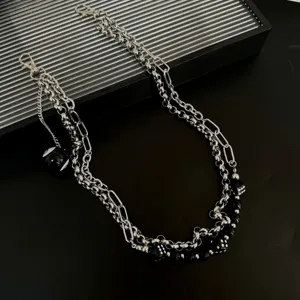 Detail shot of hip-hop punk multi-layer metal pants chain with billiard ball and dice pendants.