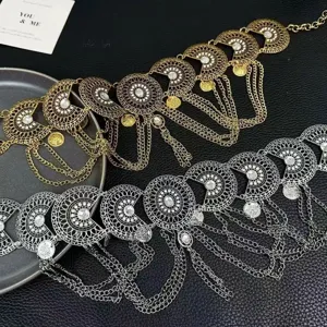 Ethnic vintage coin tassel waist chain detail view, gold and silver metal alloy design.