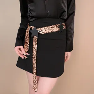 Cintura da donna alla moda con stampa leopardato e ciondoli a stella per outfit casual.