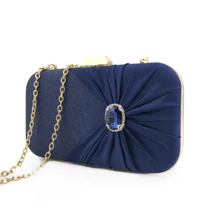 Dark blue pleated evening clutch bag with blue rhinestone centerpiece, gold chain and hardware.