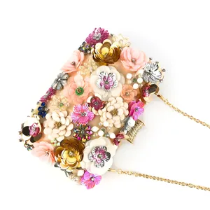 Close-up detail of luxury handmade floral beaded evening clutch bag with sequins and gold chain.