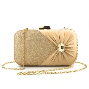 Gold evening clutch bag featuring glitter and pleated satin with crystal charm detail.