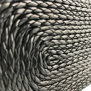 Black woven PU leather bag detail, fine braided texture close up, elegant fashion accessory.