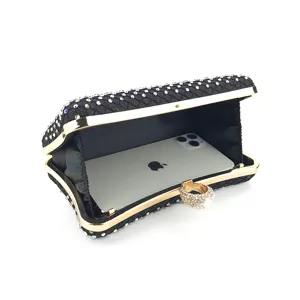 Schwarze Strass-Abendtasche mit goldem Metallrahmen und Ringgriff für Damen.