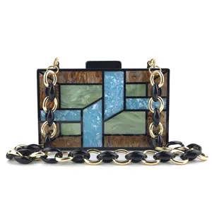 Sac de soirée pochette géométrique en acrylique avec grosse chaîne noire et dorée.