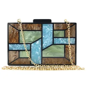 Gros plan sur la texture acrylique géométrique et la chaîne dorée de cette pochette de soirée chic.