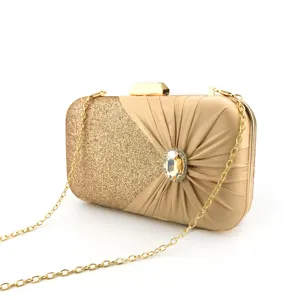 Elegant gold evening clutch bag with glitter, pleated satin, and rhinestone brooch for party.