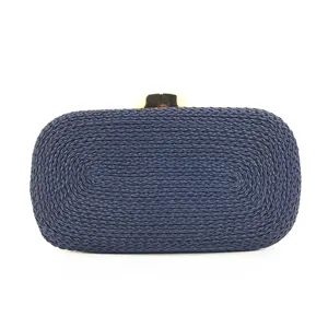 Detailed view of dark blue handmade woven evening clutch bag with gold metal clasp.