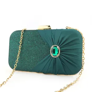 Dark green glitter evening clutch bag with gold chain and emerald rhinestone clasp detail.