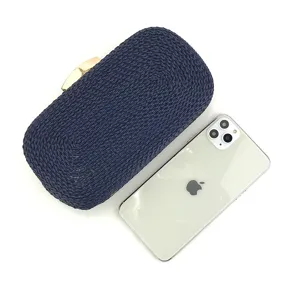 Detail view of a navy blue woven clutch handbag featuring a sleek gold-tone clasp closure.