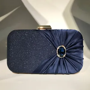 Rhinestone evening bag detail, dark blue satin clutch with sparkling glitter and crystal buckle.