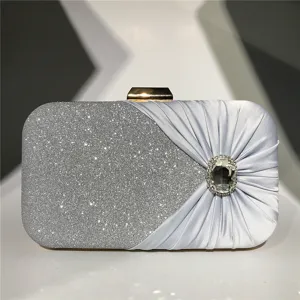 Exquisite detail of evening clutch bag featuring sparkling glitter and pleated rhinestone design.