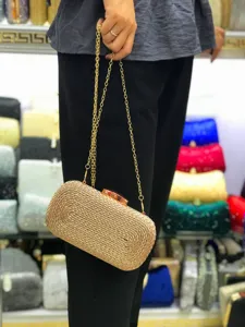 Detailed view of gold woven clutch bag with chain strap, perfect evening bag showcase.