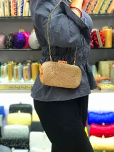 Handmade woven straw clutch bag for women, elegant evening bag with gold chain strap detail.