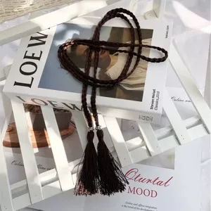 Detailed shot of a dark brown braided tassel belt, vintage bohemian rope accessory style.