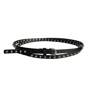 Close-up detail of black punk studded leather belt with metal eyelets and silver buckle.