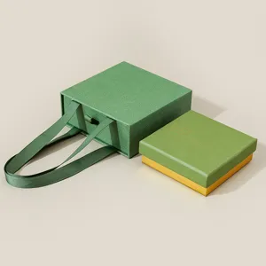 Grüne Schubladen-Schmuckgeschenkbox mit Bandgriff und Goldbox für Ringe und Halsketten.