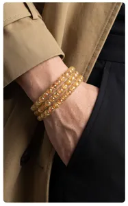 Close-up detail shot of a natural golden rutile quartz crystal beaded multi-wrap bracelet.
