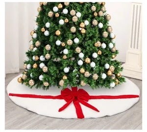 Detailed view of white plush Christmas tree skirt with red velvet bow decoration and festive tree.