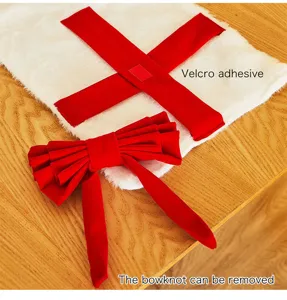Plush Christmas tree skirt detail view featuring a detachable red bow and velcro adhesive straps.